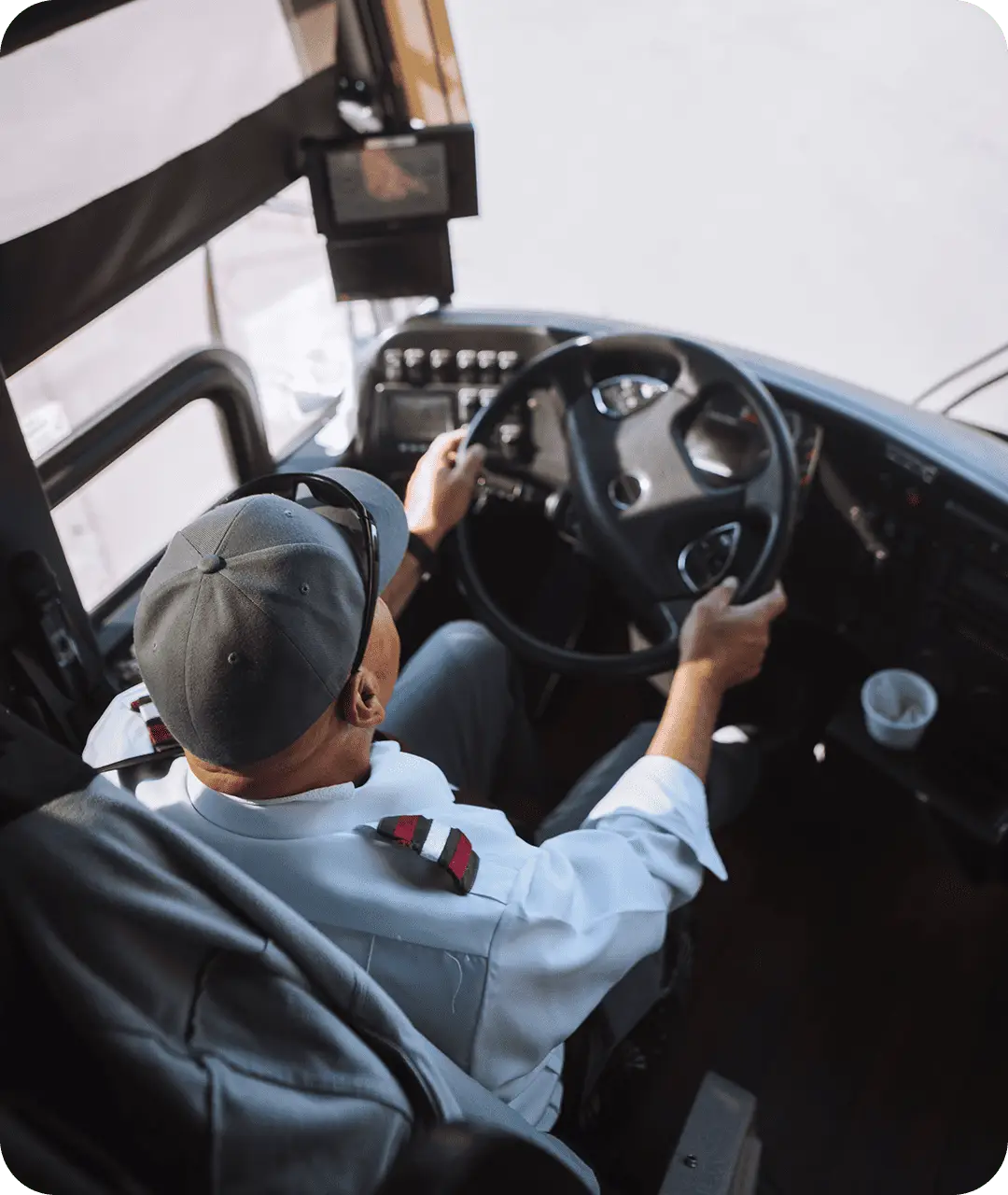 An All Aboard America driver in uniform navigates a motorcoach from the driver seat with dashboard instruments visible