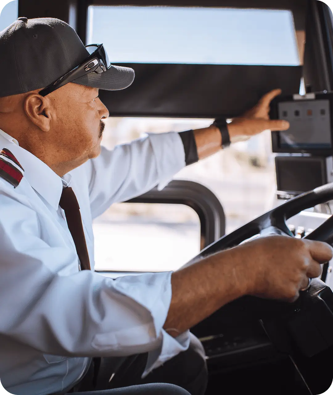 An All Aboard America driver in uniform adjusts the onboard monitoring screen while driving