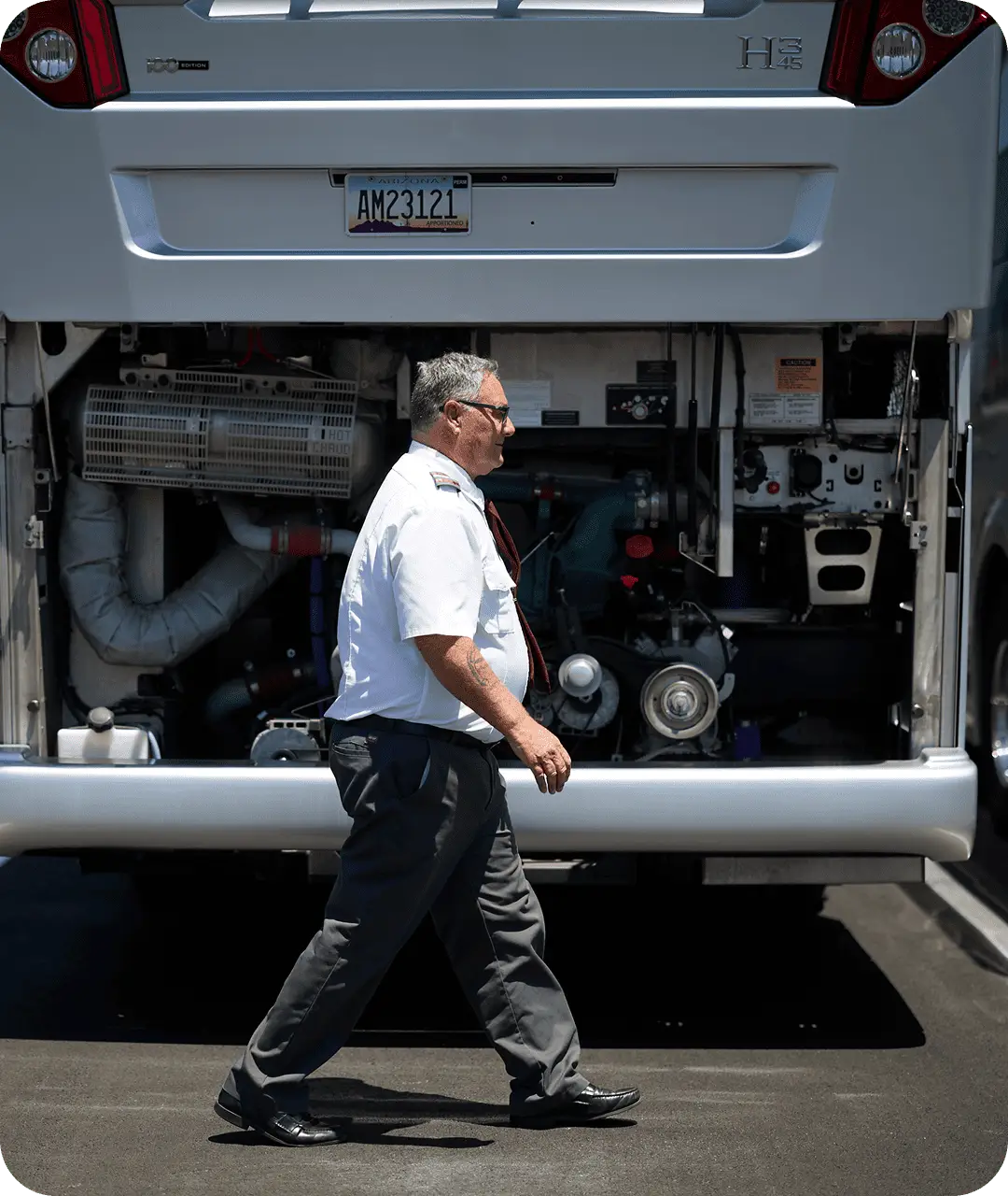 A driver for All Aboard America walks around the bus while performing a safety check before driving