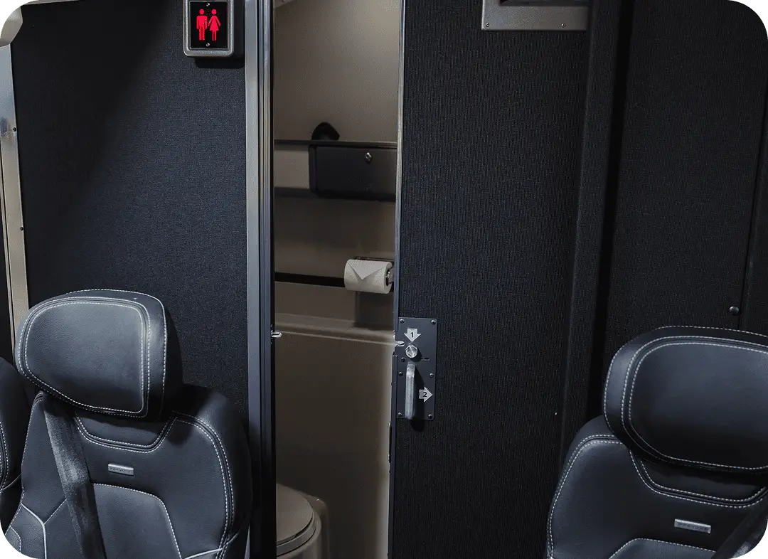 Onboard restroom facility inside an All Aboard America motorcoach with privacy door