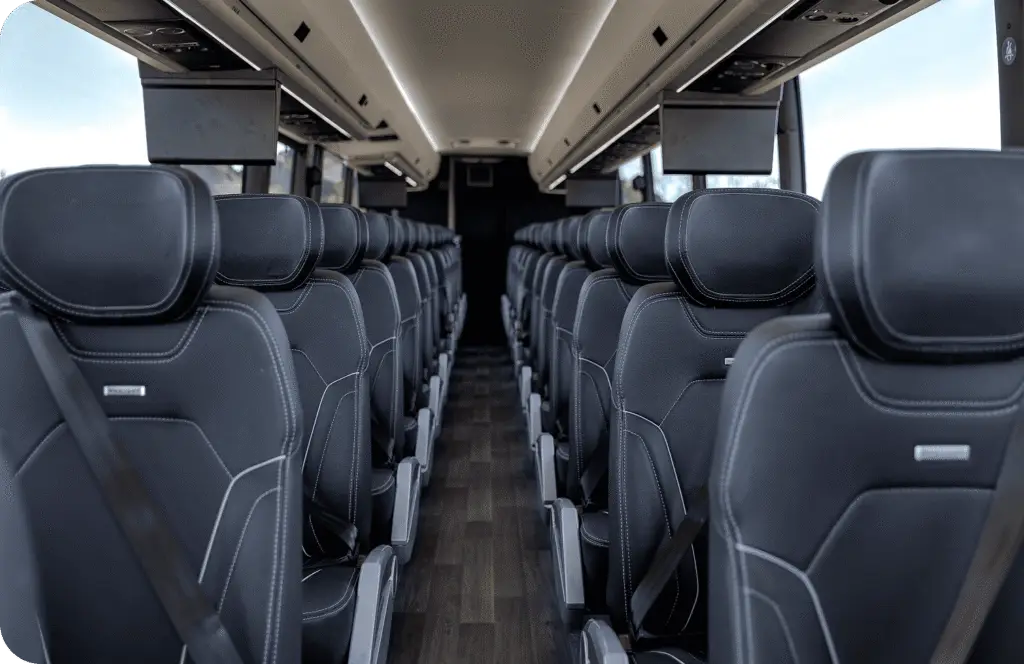 An All Aboard America Prevost motorcoach parked at dusk with desert scenery