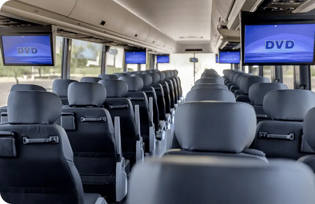 An All Aboard America Prevost motorcoach parked at dusk with desert scenery