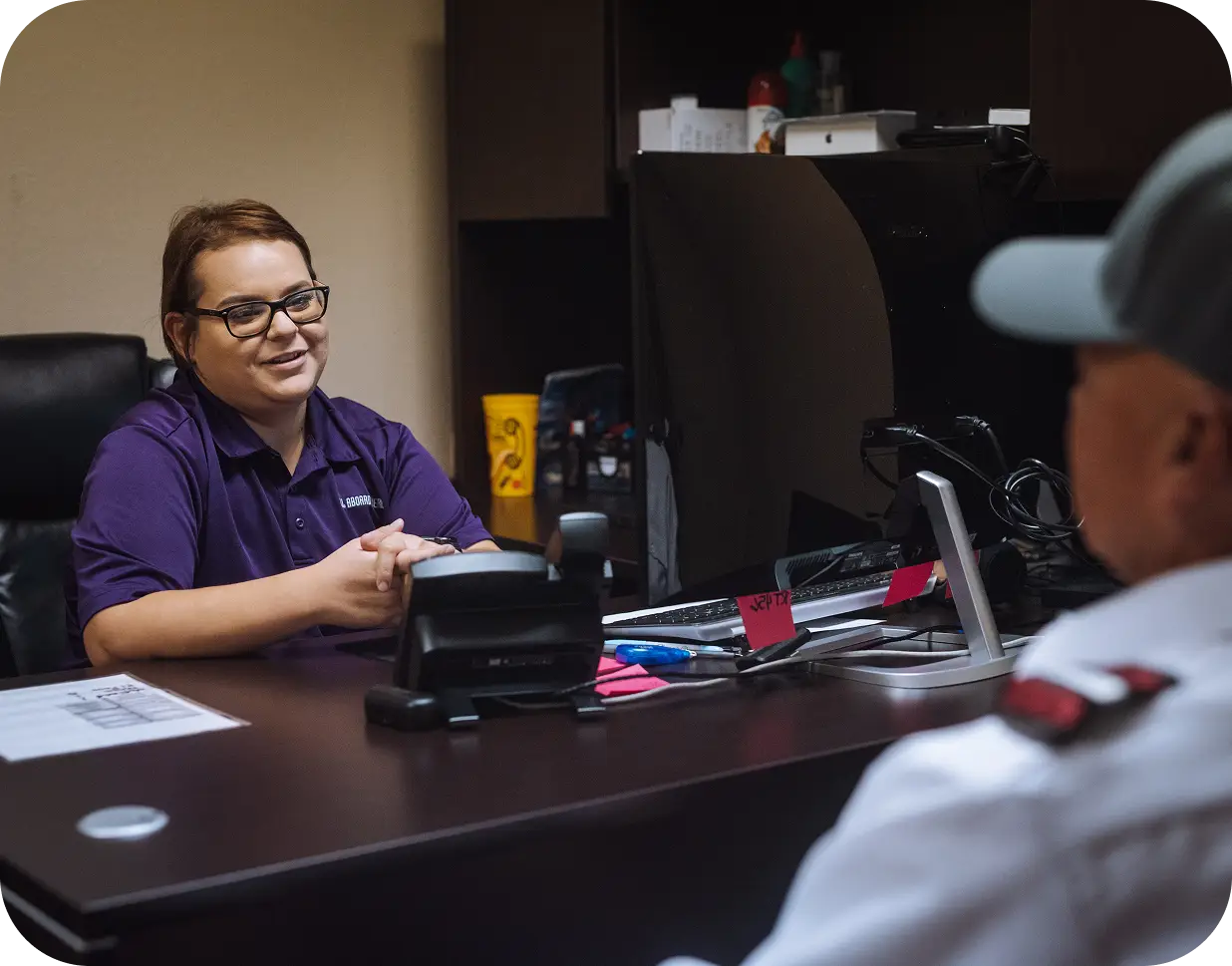 An All Aboard America office staff member smiles while meeting with a driver to coordinate charter trip details