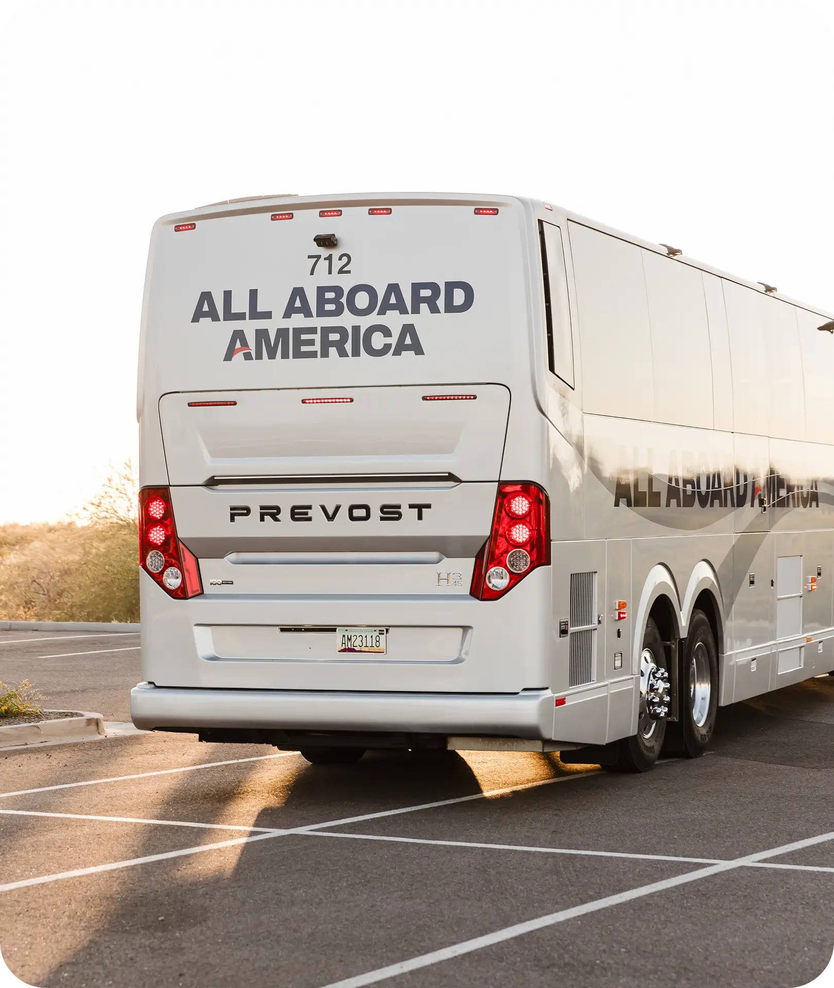 Rear view of an All Aboard America Prevost motorcoach parked in a desert lot ready for an over-the-road charter trip