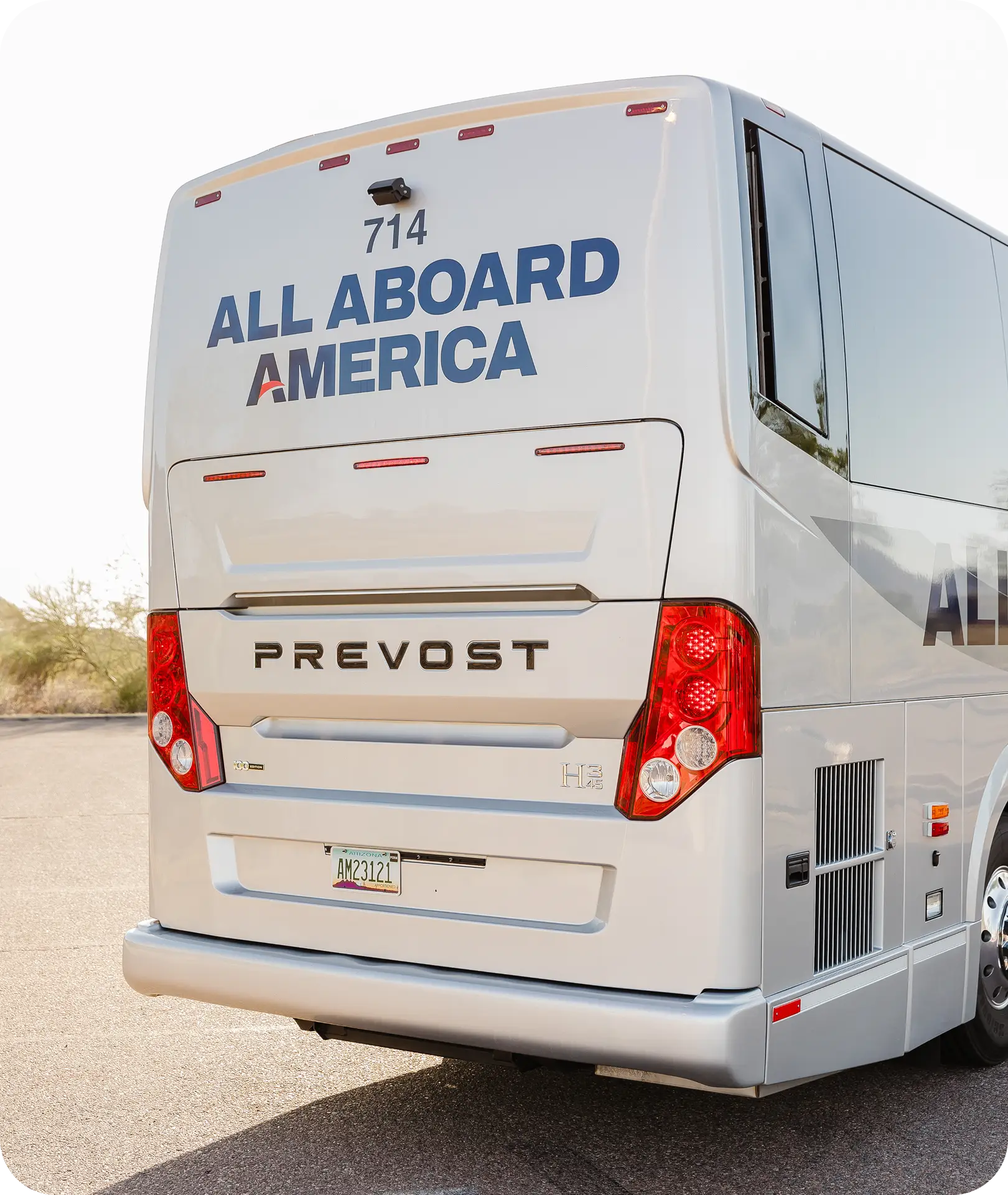 Rear view of an All Aboard America Prevost motorcoach number 714 parked in a desert lot