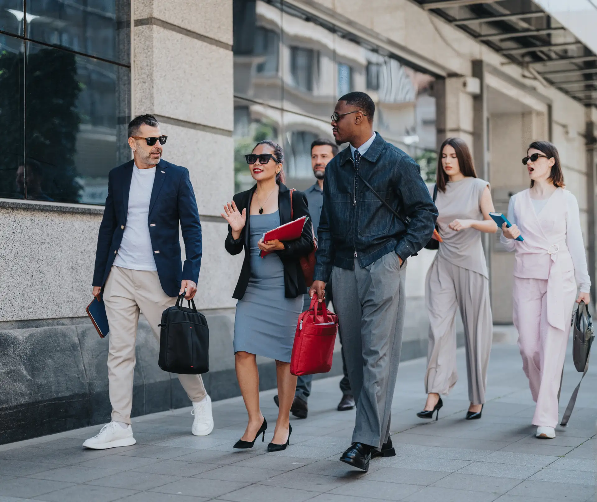 A group of business professionals walk together along a city sidewalk representing All Aboard America corporate commuter clients