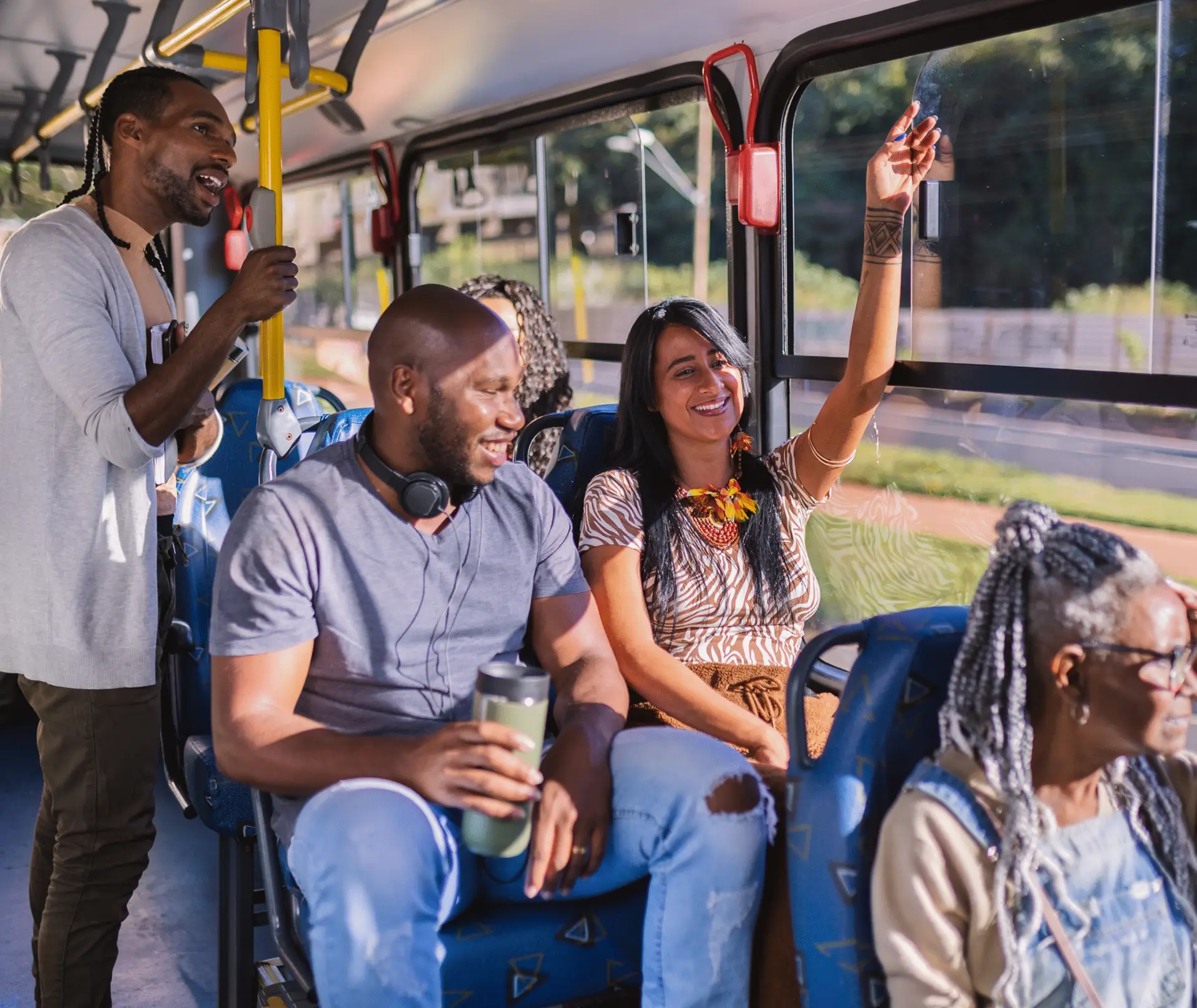 Diverse group of passengers laugh and socialize aboard an All Aboard America fixed route transit bus