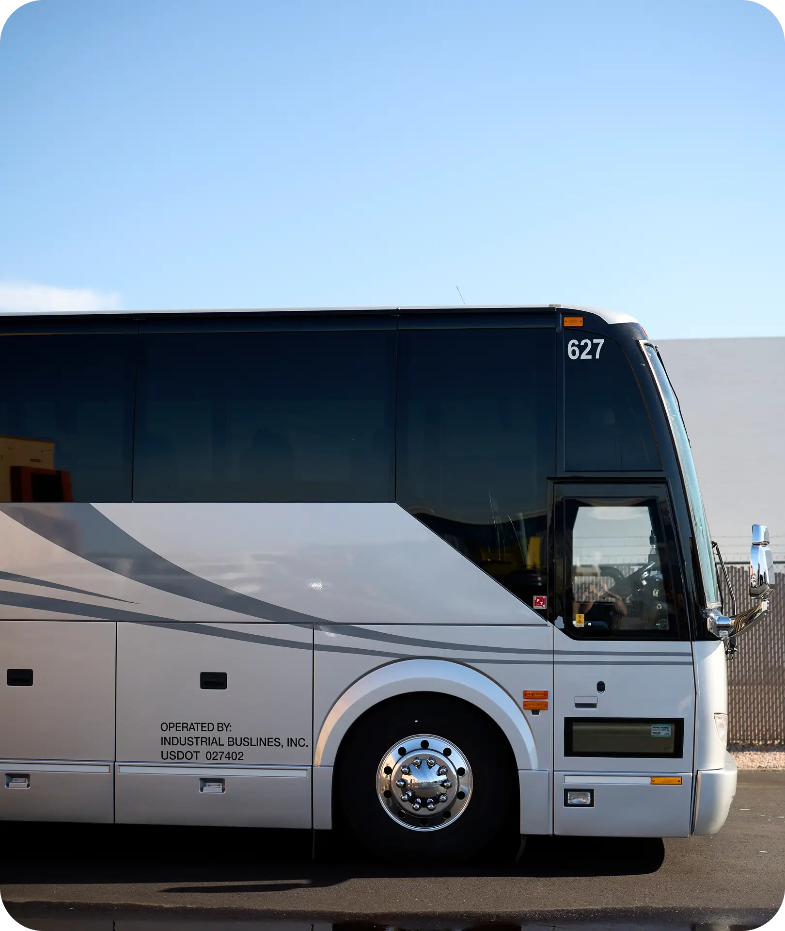 Side view of an All Aboard America motorcoach number 627 parked against a clear blue sky for industrial workforce transport